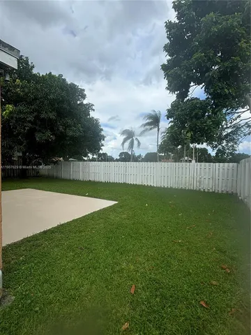 a backyard of a house with lots of green space and plants