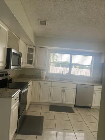 a large kitchen with cabinets and steel stainless steel appliances