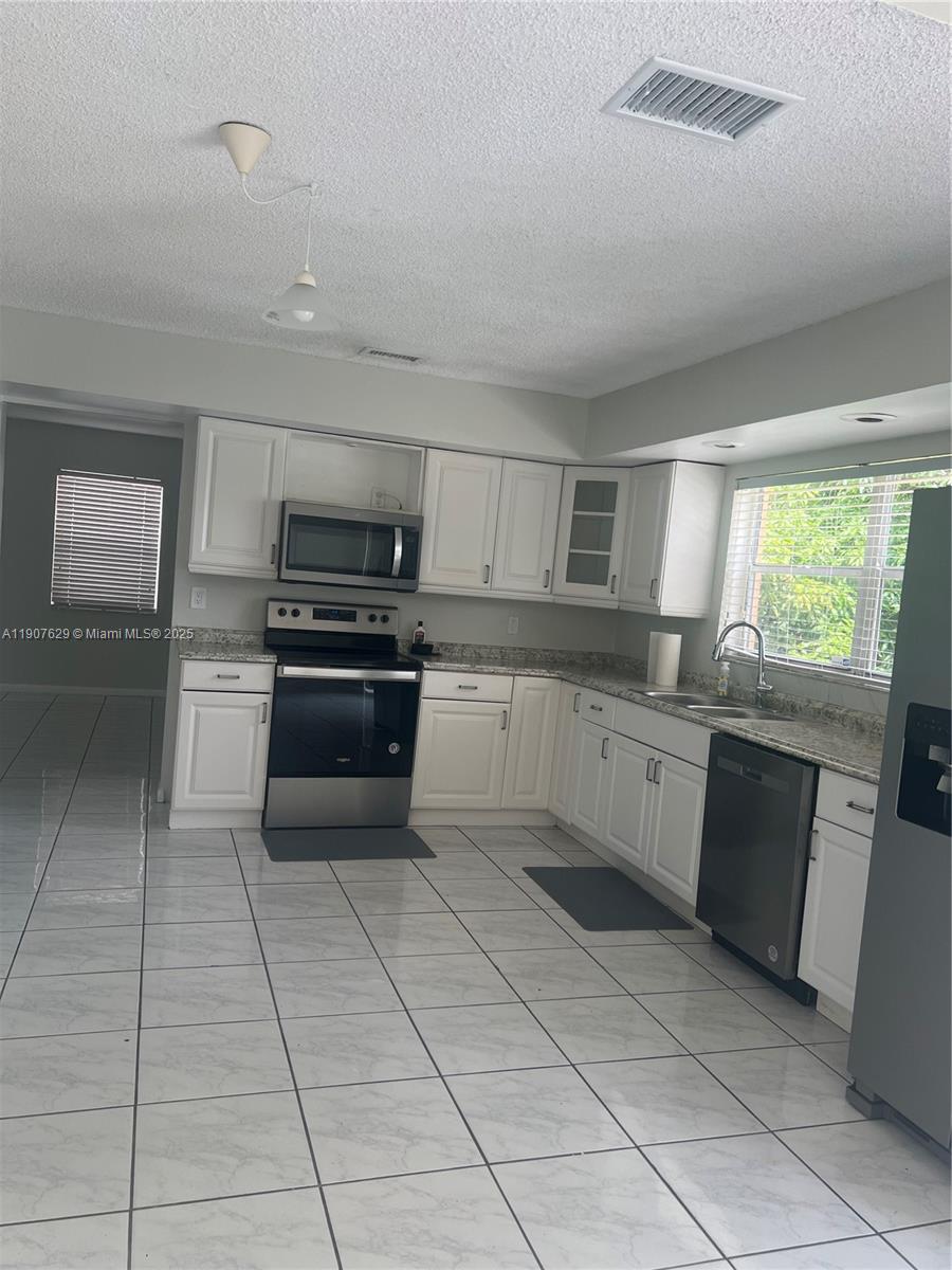 River Run Miramar, FL 33025 - Photo 22 of 29 a large kitchen with cabinets and steel stainless steel appliances
