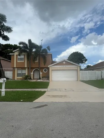 a view of a house with a yard and a street