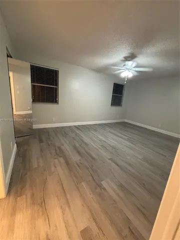 a view of a livingroom with wooden floor and a ceiling fan