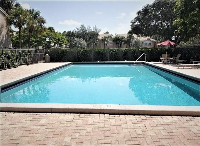 9601 Riverside Drive, Unit A10 Coral Springs, FL 33071 - Photo 11 of 15 a view of a swimming pool with a yard