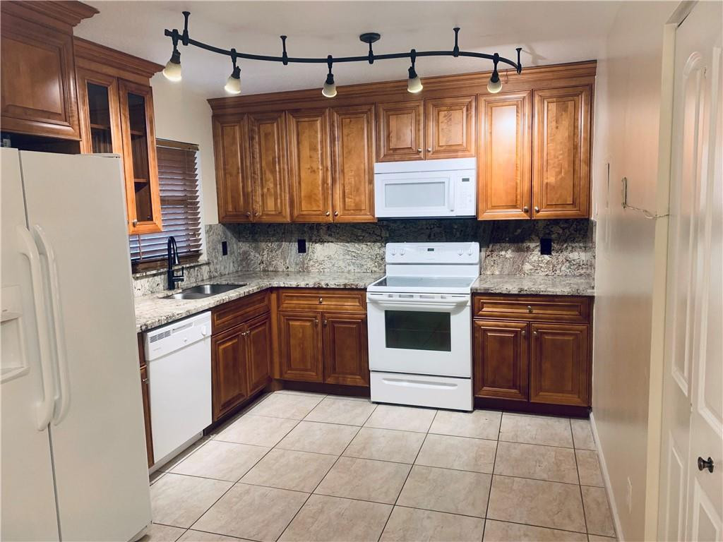 9601 Riverside Drive, Unit A10 Coral Springs, FL 33071 - Photo 13 of 15 a kitchen with a stove a sink and a refrigerator