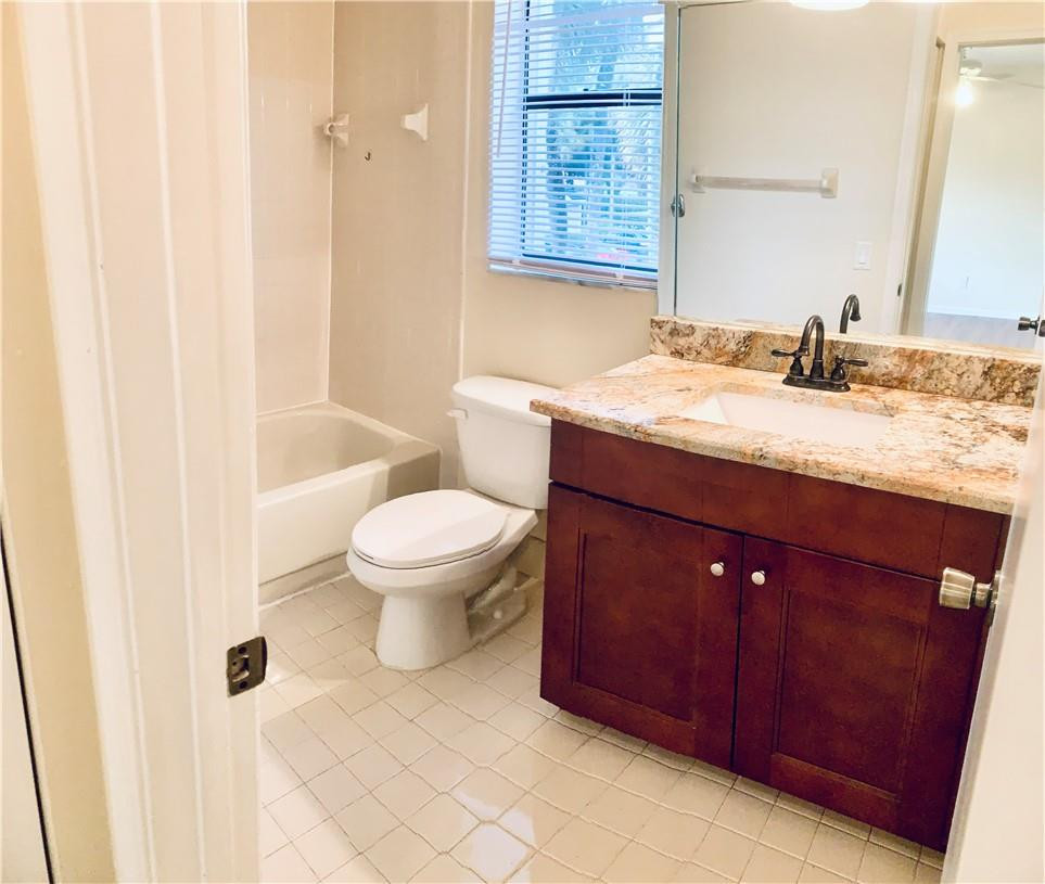9601 Riverside Drive, Unit A10 Coral Springs, FL 33071 - Photo 3 of 15 a bathroom with a granite countertop sink toilet and shower