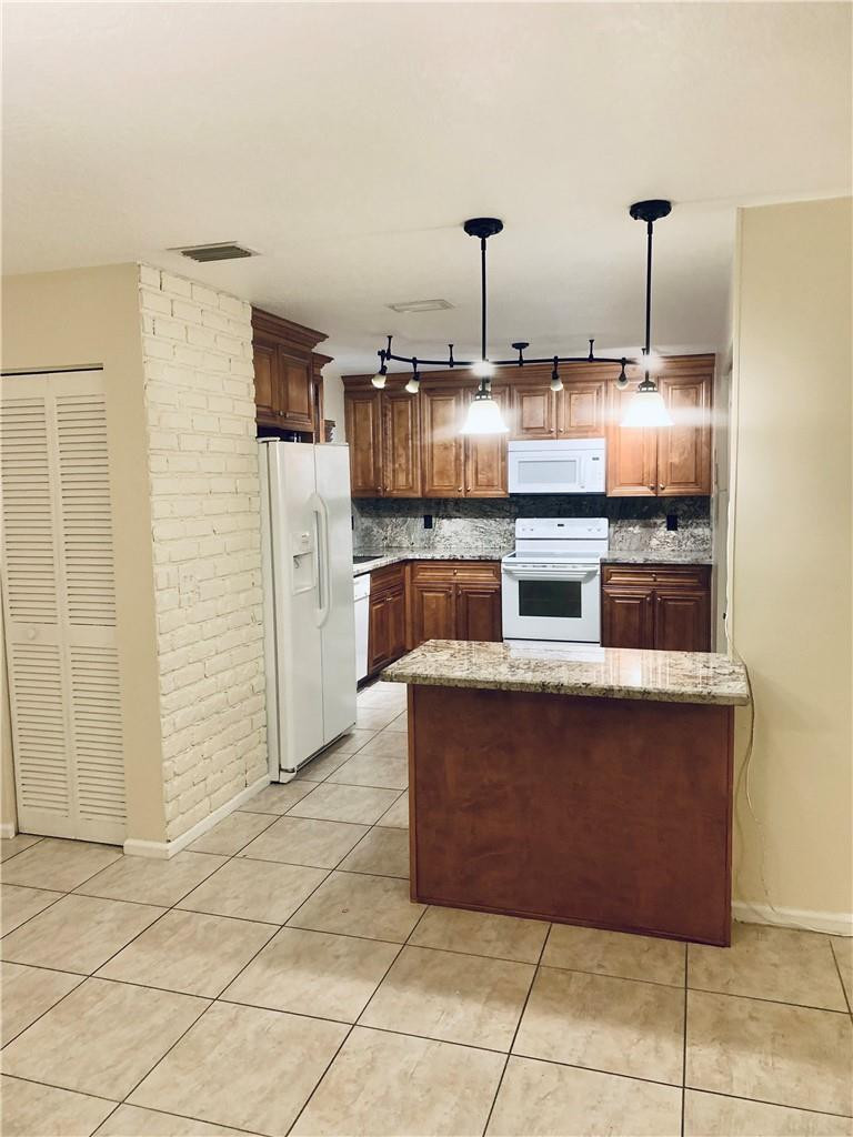 9601 Riverside Drive, Unit A10 Coral Springs, FL 33071 - Photo 8 of 15 a kitchen with stainless steel appliances granite countertop a stove a refrigerator and a sink