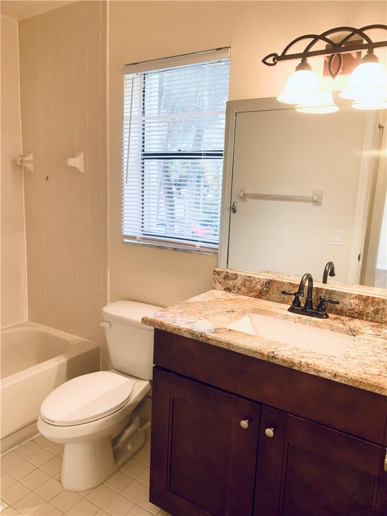 9601 Riverside Drive, Unit A10 Coral Springs, FL 33071 - Photo 10 of 15 a bathroom with a granite countertop sink toilet and shower