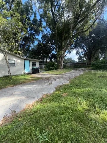 a view of a yard with a house and large tree