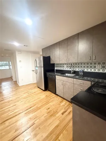a view of a kitchen with a refrigerator and a window