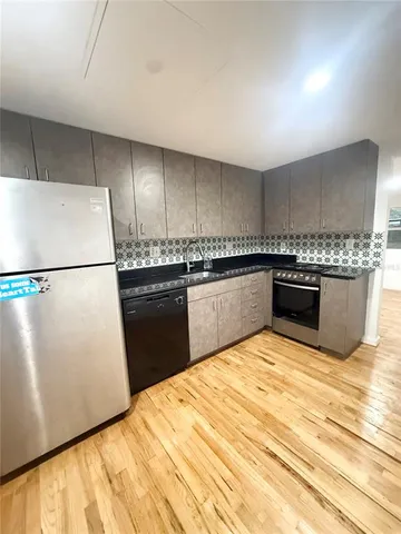 a kitchen with stainless steel appliances granite countertop a stove a sink and a refrigerator