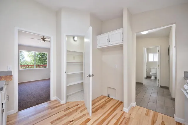 a view of an empty room with bathroom and a window