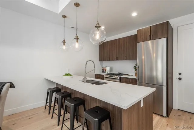 a kitchen with stainless steel appliances a table chairs and refrigerator