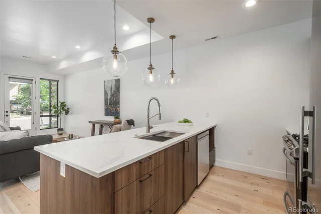 a kitchen with a sink a counter space and a chandelier