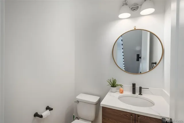 a bathroom with a sink mirror and toilet