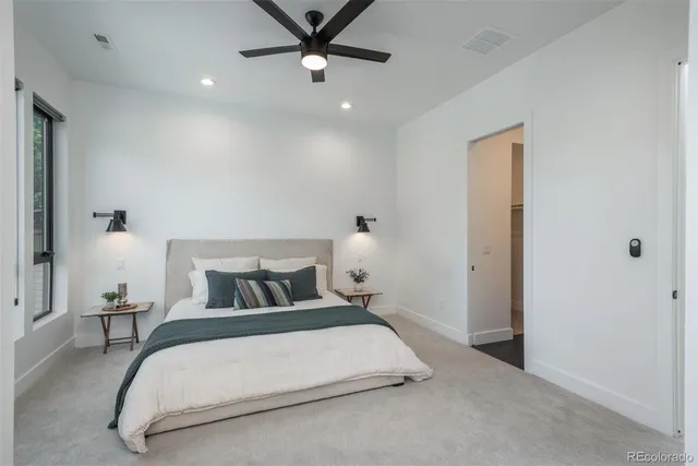 a bedroom with a bed and a ceiling fan