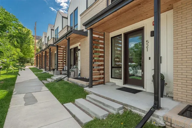 a view of a house with a large windows and plants