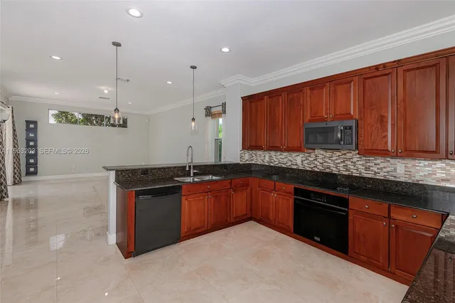 a kitchen with stainless steel appliances granite countertop wooden cabinets a stove a sink and a granite counter tops