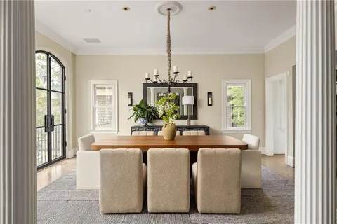 a dining room with furniture a chandelier and wooden floor