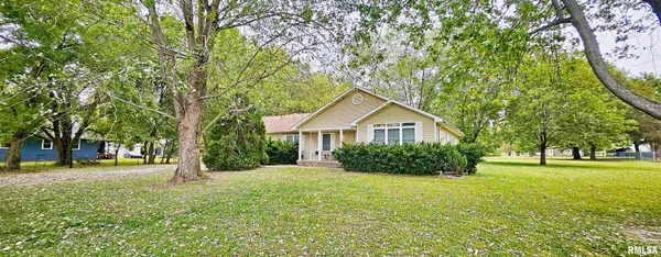 a front view of a house with a yard and trees
