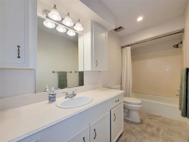 a bathroom with a sink a toilet a mirror and shower