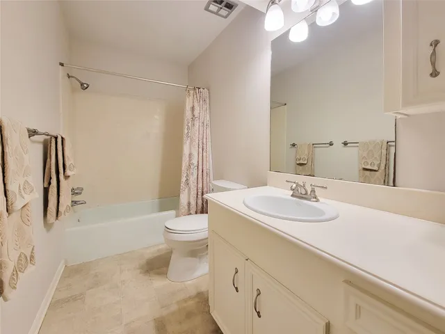 a bathroom with a sink a toilet and a large mirror