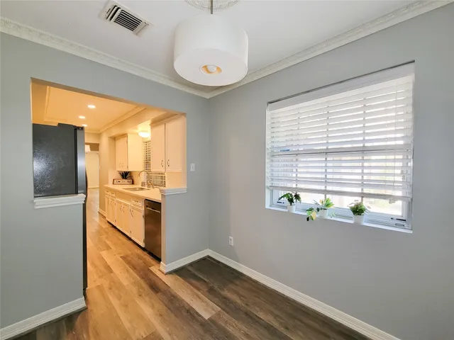 a kitchen with a white cabinets and wooden floor