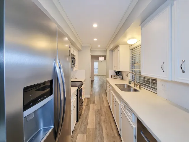 a kitchen with stainless steel appliances a sink a stove and a refrigerator