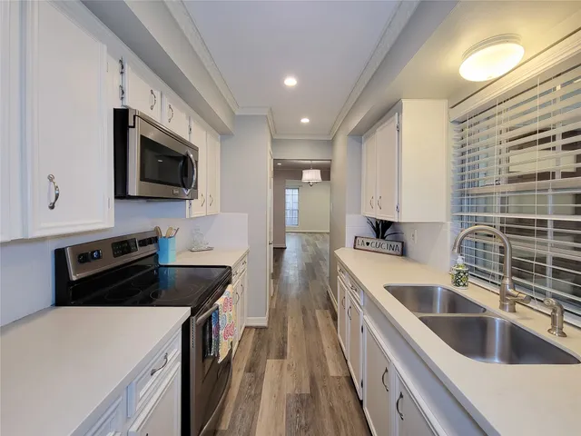 a kitchen with stainless steel appliances a stove sink microwave and cabinets