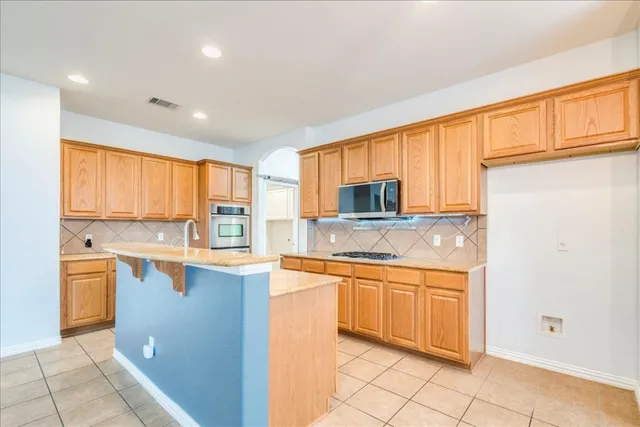 a kitchen with a sink stove top oven and cabinets
