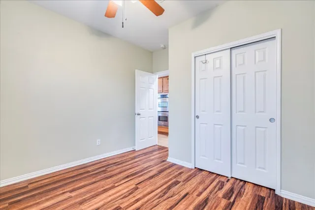 an empty room with windows and fan