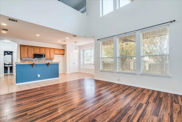 a view of empty room with wooden floor and windows