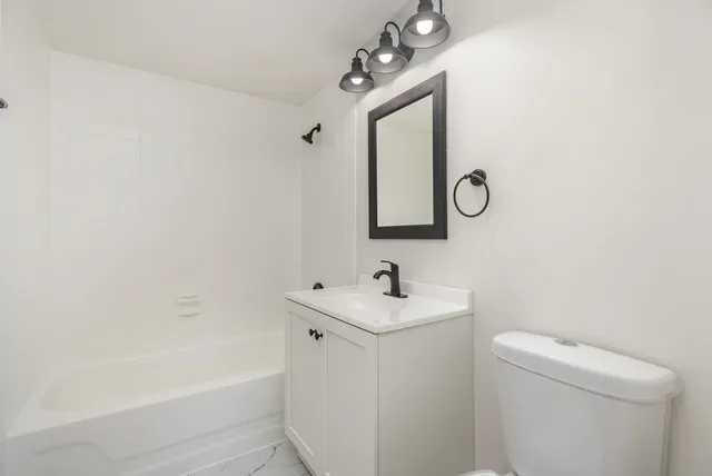 a bathroom with a toilet a sink and mirror