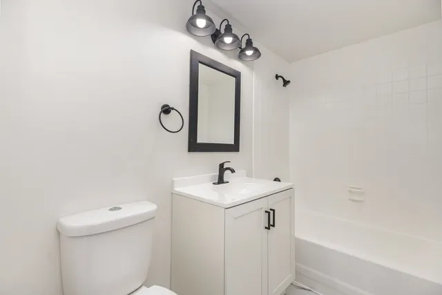 a bathroom with a sink toilet and mirror