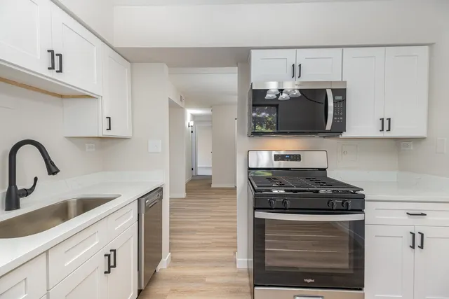 a kitchen with stainless steel appliances a stove a microwave and sink