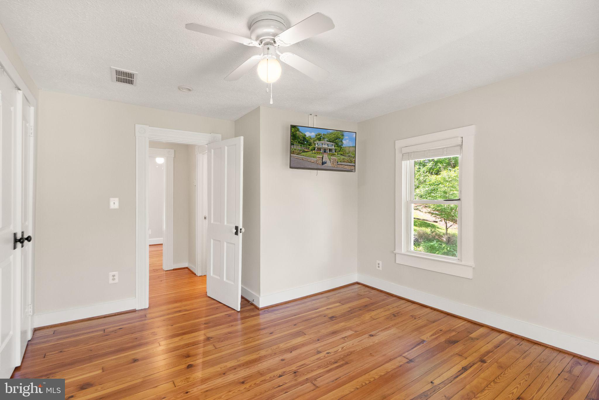 37151 Branchriver Road Purcellville, VA 20132 - Photo 37 of 63 an empty room with wooden floor ceiling fan and windows