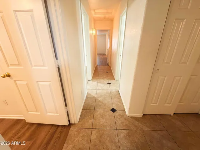a view of a hallway with wooden floor and entryway