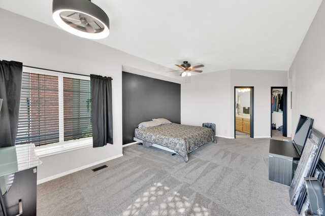 5057 South Ridgedale Drive Ogden, UT 84403 - Photo 21 of 69 Spacious carpeted room featuring a prominent window, a vaulted ceiling, and two ceiling fans