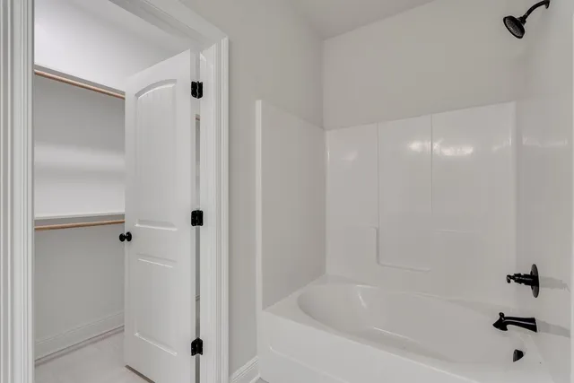 a white bath tub sitting next to a shower