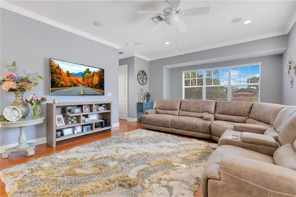 a living room with furniture a flat screen tv and a floor to ceiling window