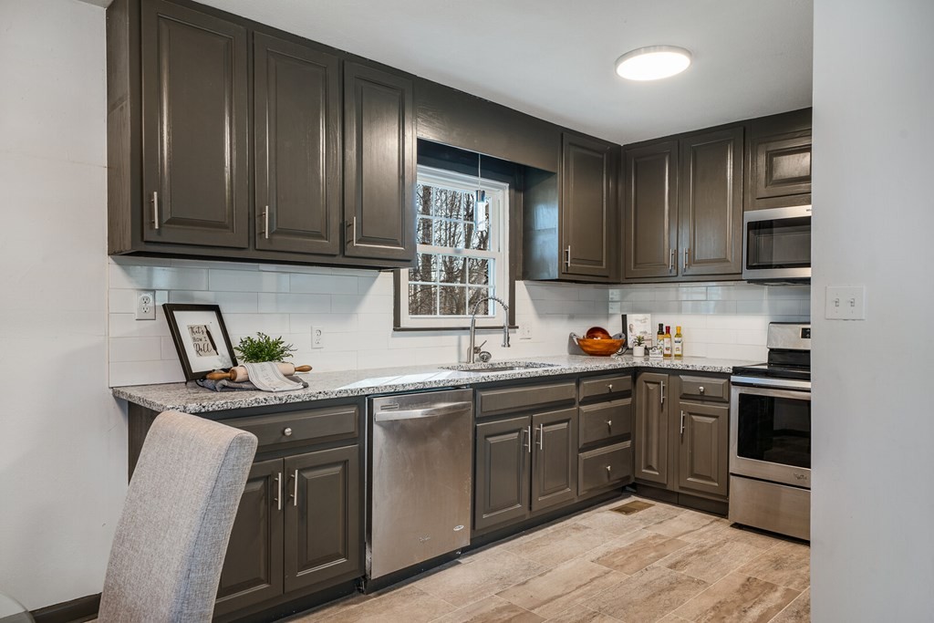329 Sunny Point Road Baxter, TN 38544 - Photo 12 of 25 a kitchen with stainless steel appliances granite countertop wooden cabinets a sink and dishwasher