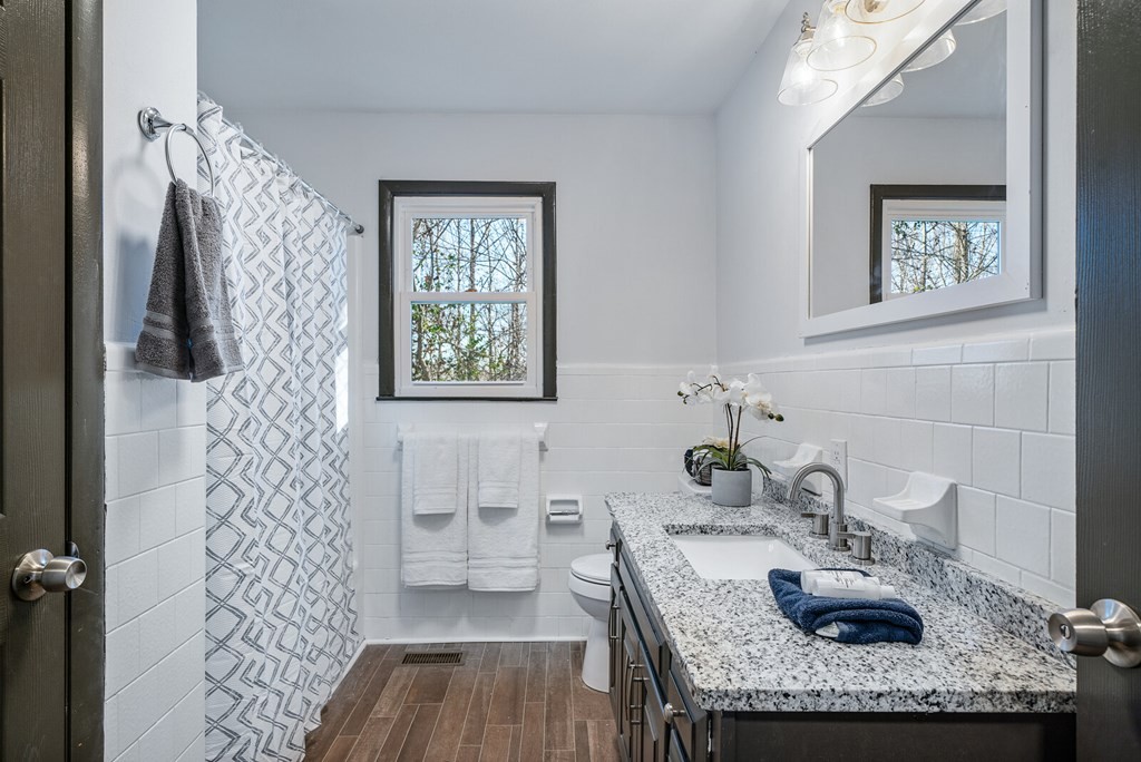329 Sunny Point Road Baxter, TN 38544 - Photo 19 of 25 a bathroom with a granite countertop sink a toilet and shower