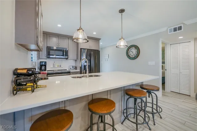 a kitchen with stainless steel appliances a table chairs and a refrigerator