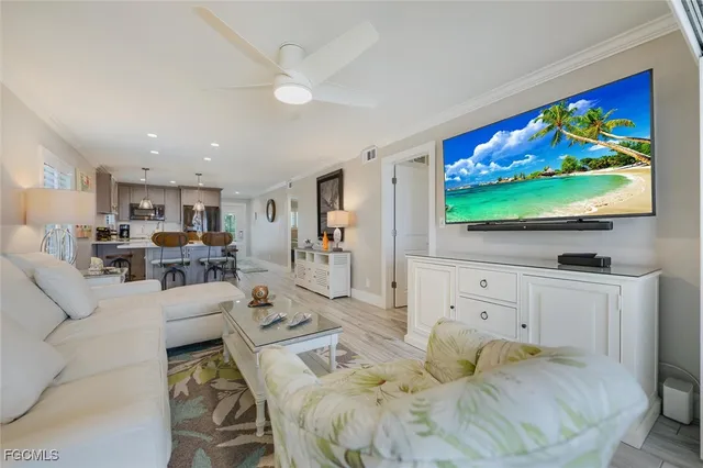 a living room with furniture kitchen view and a large window