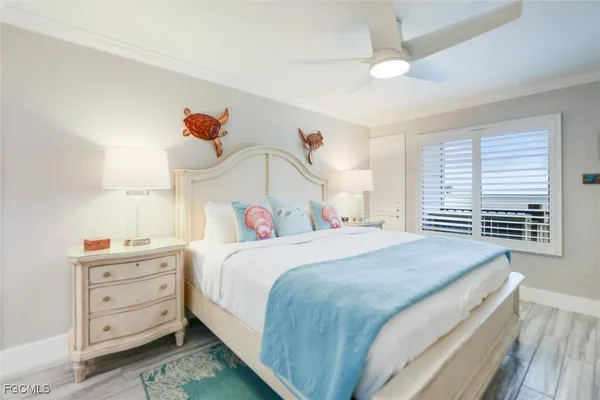 a bedroom with a bed a chandelier and a window