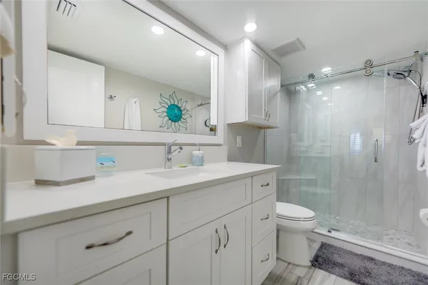 a bathroom with a sink a toilet and shower