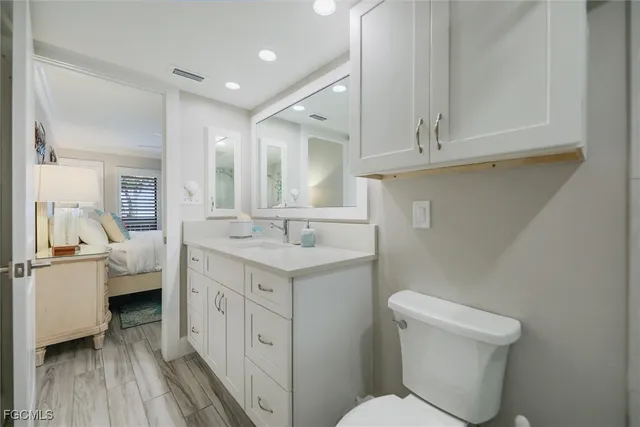 a spacious bathroom with a toilet sink and mirror