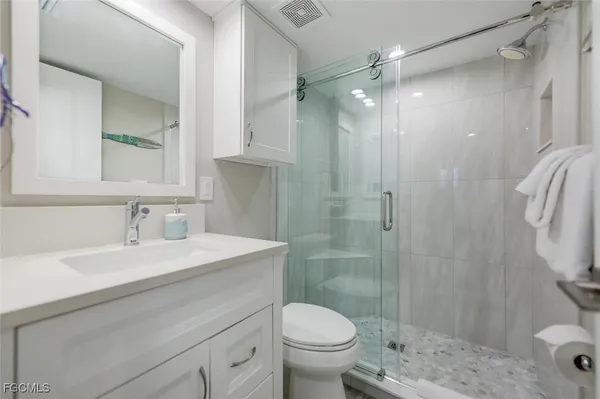 a bathroom with a sink toilet vanity and shower