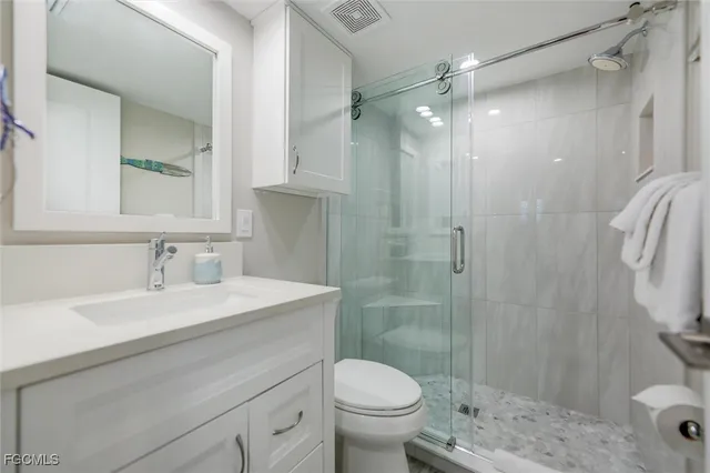a bathroom with a sink toilet vanity and shower