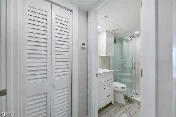 a bathroom with a granite countertop toilet a sink and shower