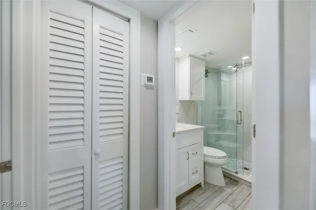 a bathroom with a granite countertop toilet a sink and shower