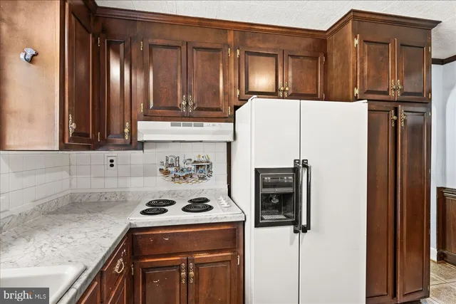 a kitchen with a refrigerator sink and cabinets